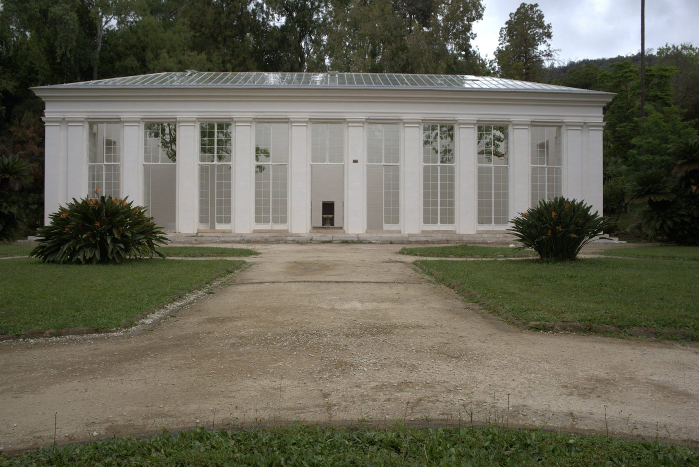 A white glasshouse pavilion in a garden
